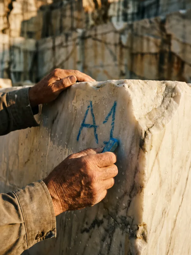 Quarry master chalk-marking a raw marble block